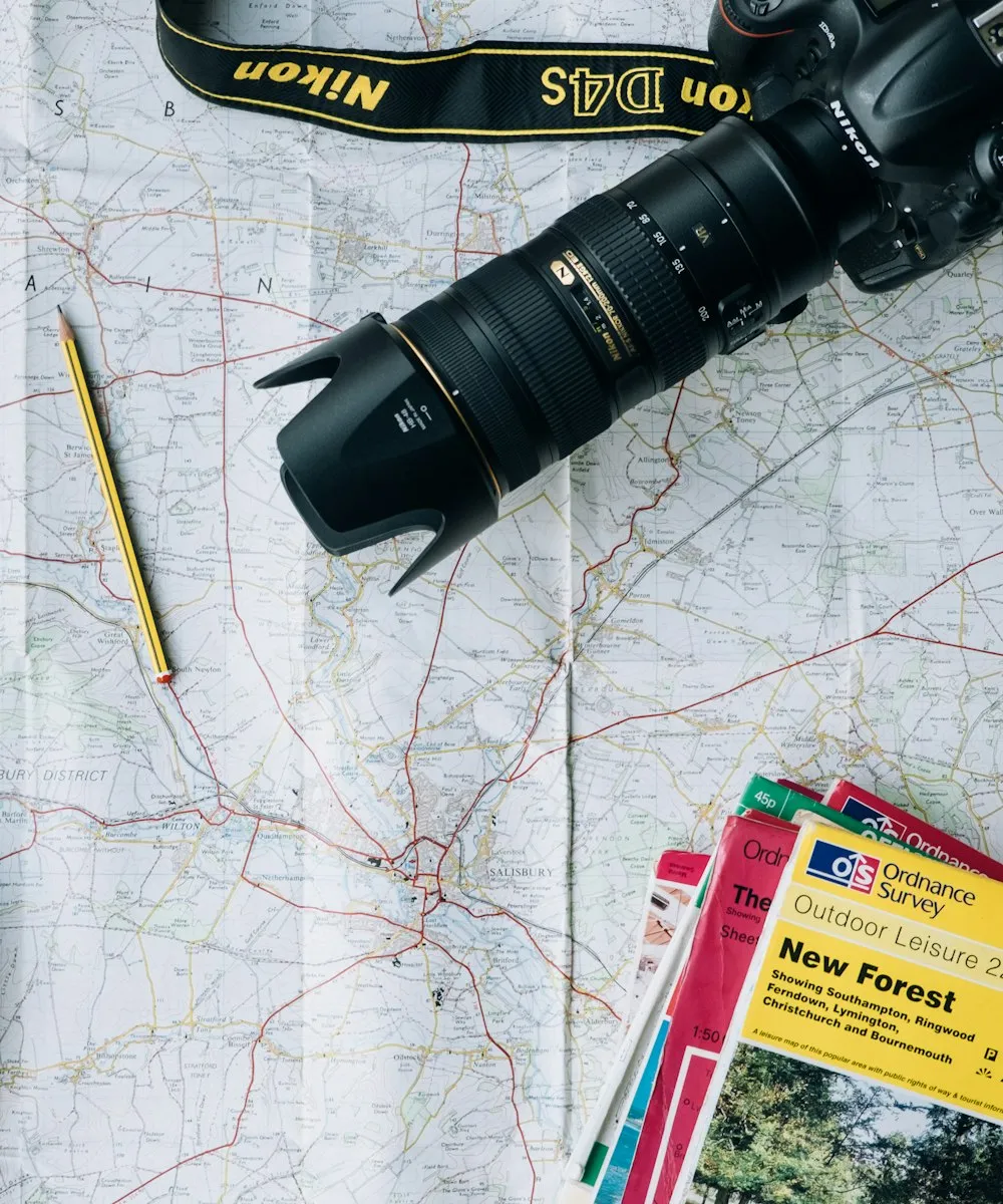 A folded map, camera and guidebooks laid out for planning a trip